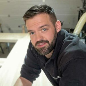 Ortwin Weber bei der Bearbeitung von einem massiven Holztisch.