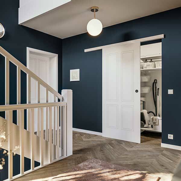 Ein heller Innenraum mit dunklen Wänden, einer weißen Treppe und einem offenen Kleiderschrank. Die Einrichtung ist modern.