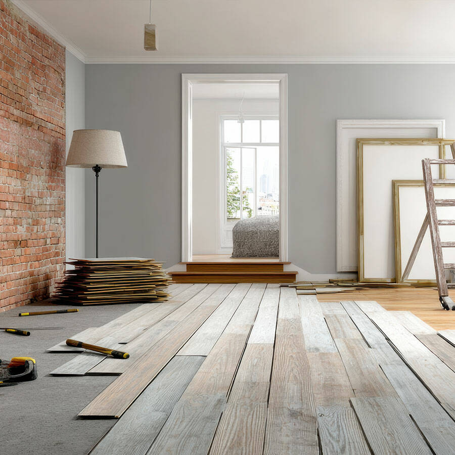 Ein Raum im Umbau mit Holzböden, Werkzeugen und einer Leiter.